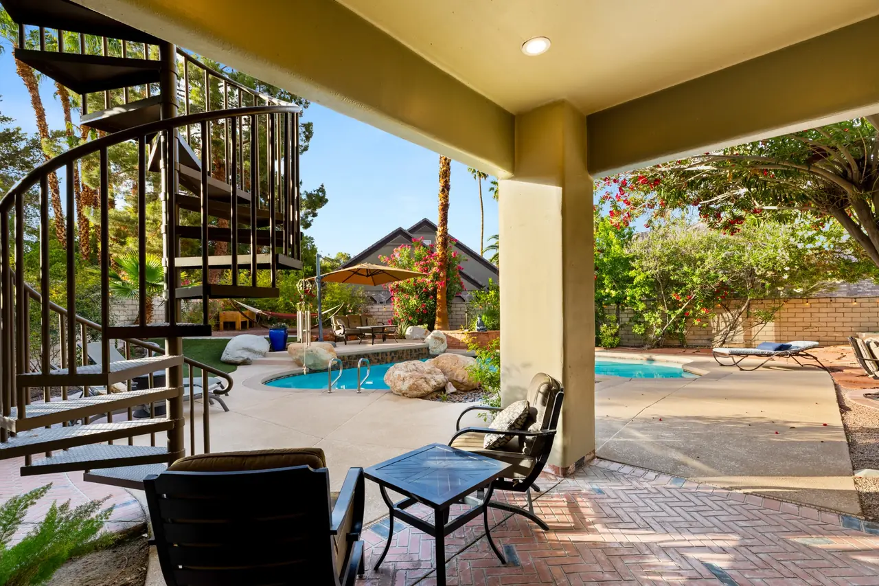 Covered patio with a spiral stair to the upstairs balcony