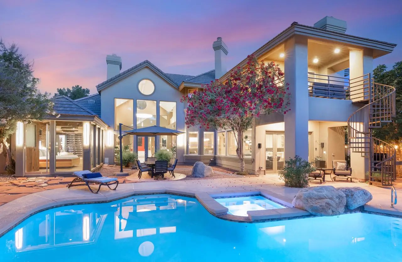 The lit pool, spa and rear of the home at twilight