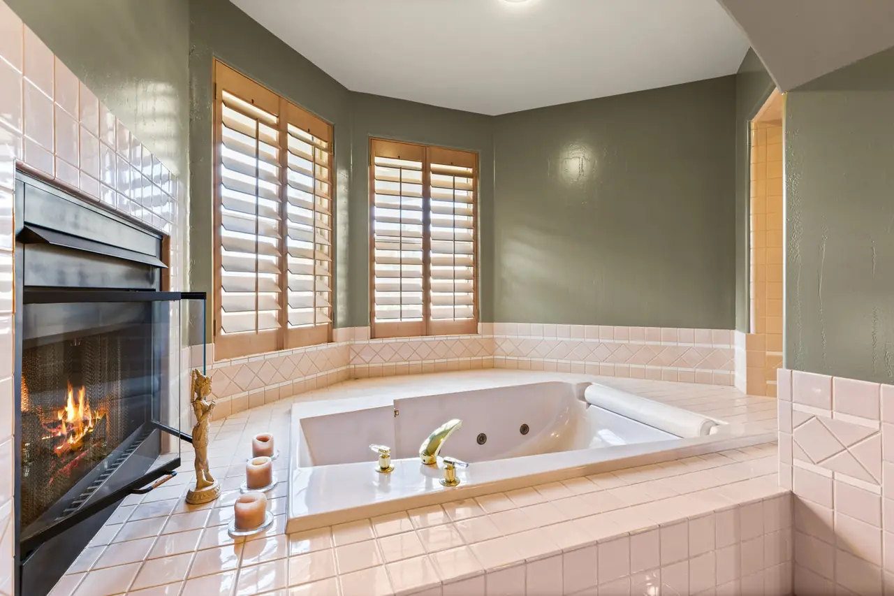 Jetted tub beside a fireplace in the second suite